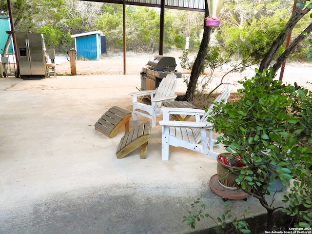 view of patio / terrace featuring an outbuilding and a grill