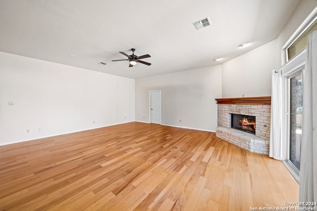 2029 Crown Rdg, Kerrville, TX 78028 - unfurnished living room featuring visible vents, a ceiling fan, a warm lit fireplace, and light wood finished floors