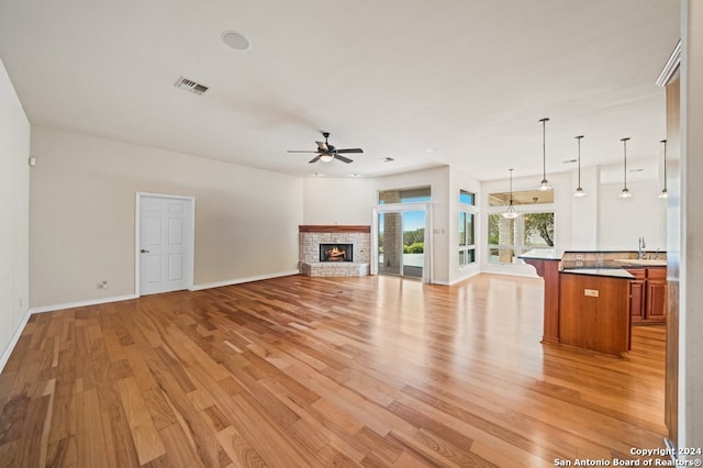 2029 Crown Rdg, Kerrville, TX 78028 - unfurnished living room featuring light wood-type flooring, a sink, baseboards, visible vents, and a ceiling fan