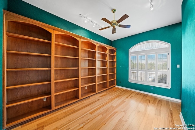 empty room with ceiling fan, rail lighting, and hardwood / wood-style floors