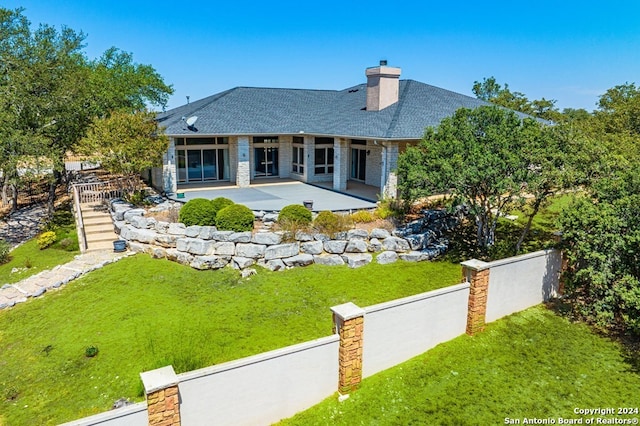 2029 Crown Rdg, Kerrville, TX 78028 - rear view of property featuring a lawn, roof with shingles, a patio area, and a chimney