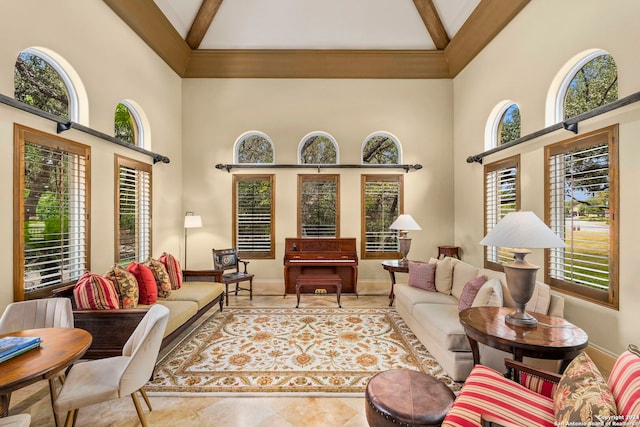 living area featuring high vaulted ceiling, baseboards, and beamed ceiling