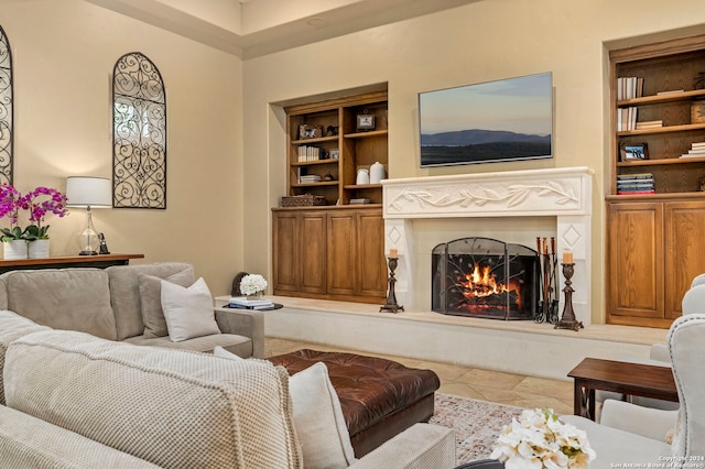 tiled living room with built in features and a warm lit fireplace