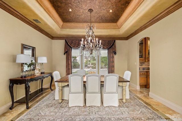 dining space featuring baseboards, visible vents, arched walkways, an inviting chandelier, and a tray ceiling