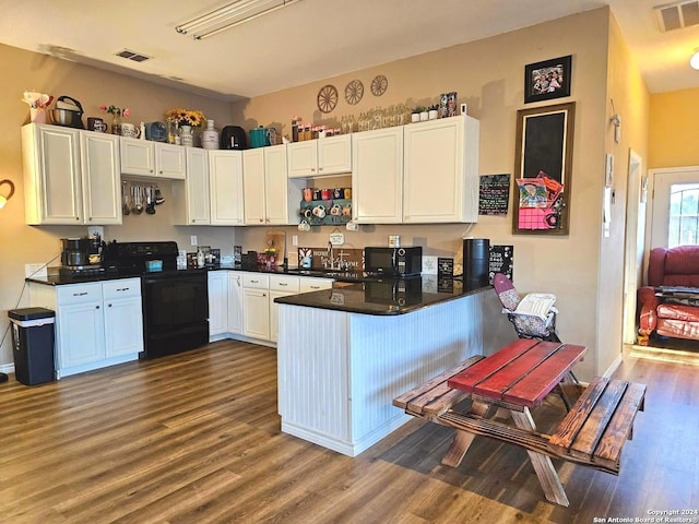 kitchen featuring kitchen peninsula, white cabinetry, wood-type flooring, black appliances, and sink