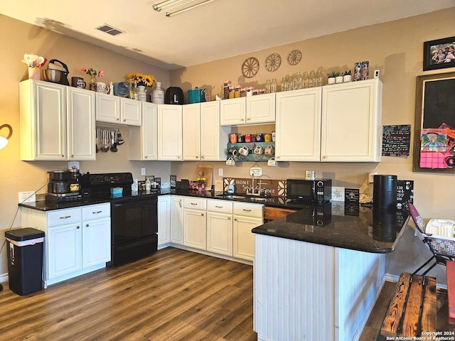 kitchen with kitchen peninsula, white cabinetry, dark hardwood / wood-style floors, black appliances, and sink