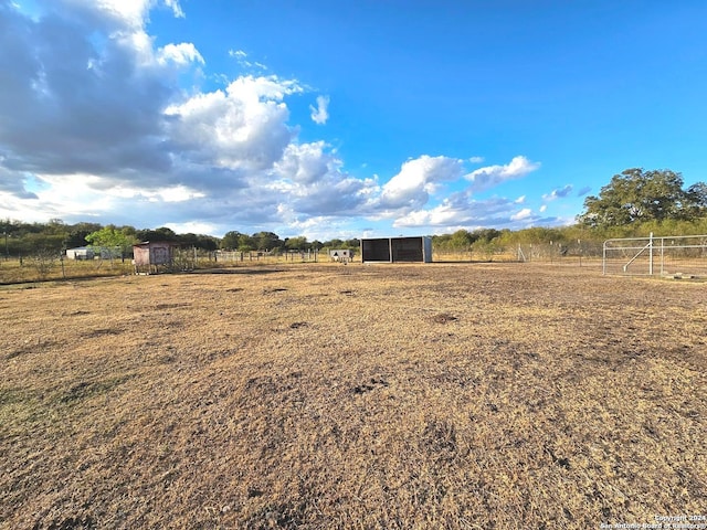 view of yard featuring a rural view and an outdoor structure