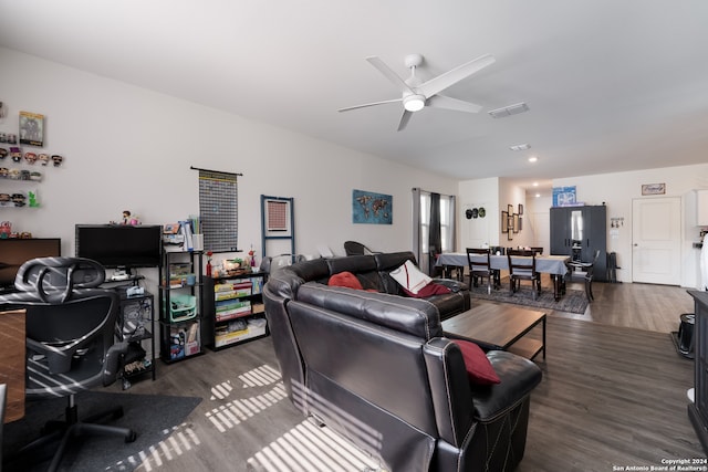 living room featuring dark wood-type flooring and ceiling fan