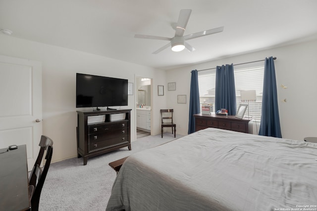 bedroom with light carpet, connected bathroom, and ceiling fan