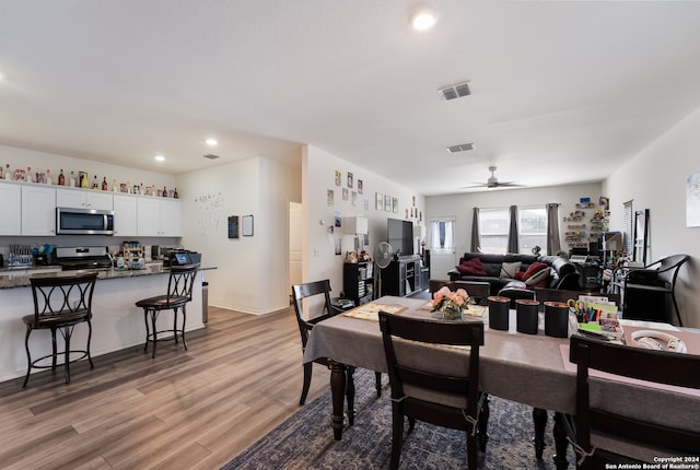 dining room with light wood-type flooring and ceiling fan