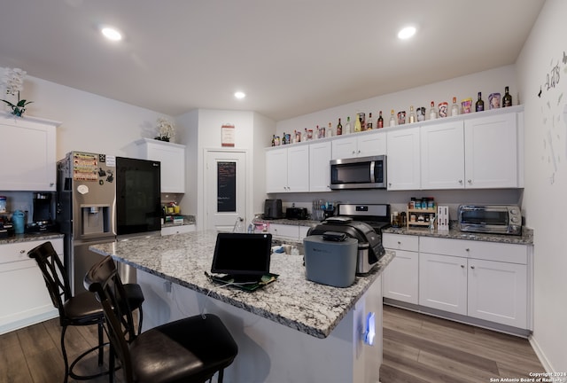 kitchen featuring appliances with stainless steel finishes, white cabinetry, and light hardwood / wood-style floors