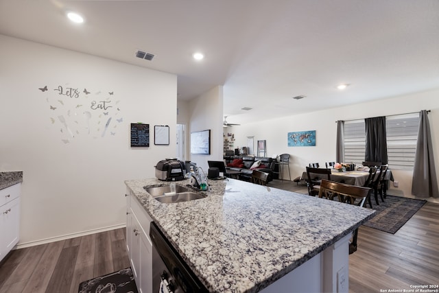 kitchen with a kitchen island with sink, dishwasher, dark hardwood / wood-style floors, and white cabinets