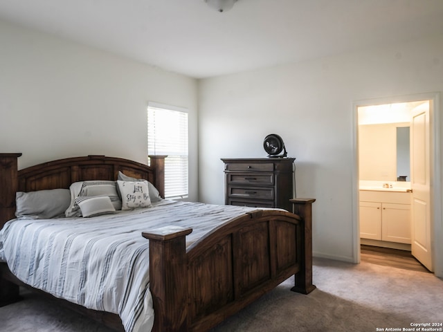 carpeted bedroom with connected bathroom and sink