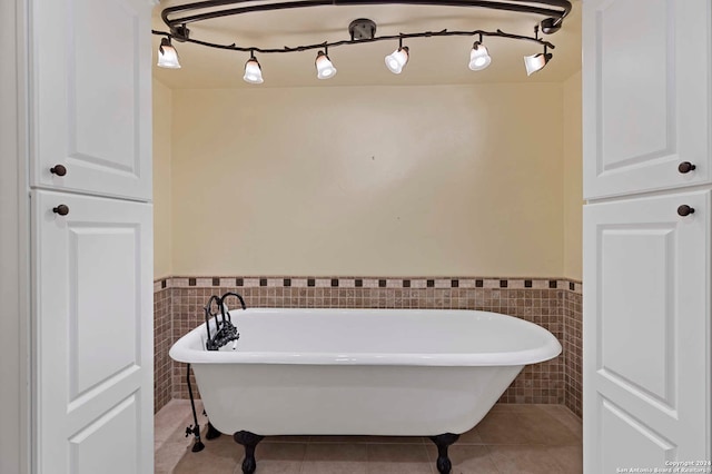 bathroom with tile walls, tile patterned flooring, and a washtub