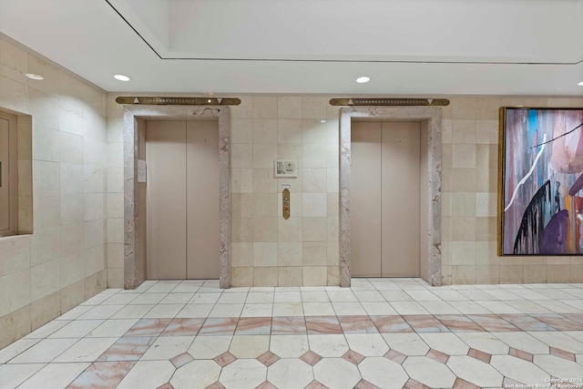 interior space featuring tile walls and elevator