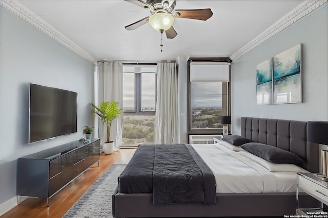 bedroom featuring crown molding, hardwood / wood-style flooring, and ceiling fan