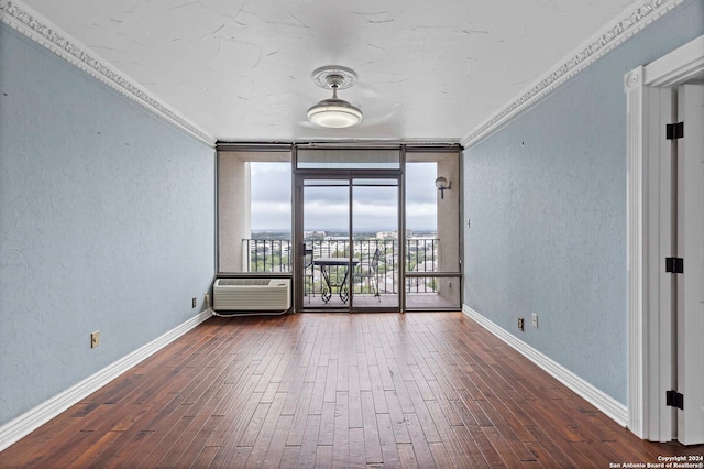 unfurnished room featuring an AC wall unit, crown molding, dark wood-type flooring, and a wall of windows