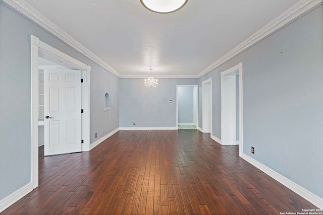 spare room featuring ornamental molding, an inviting chandelier, and dark hardwood / wood-style flooring