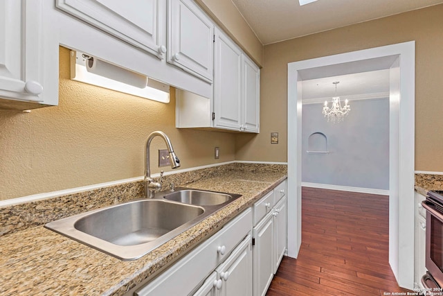 kitchen with sink, pendant lighting, white cabinets, dark wood-type flooring, and ornamental molding