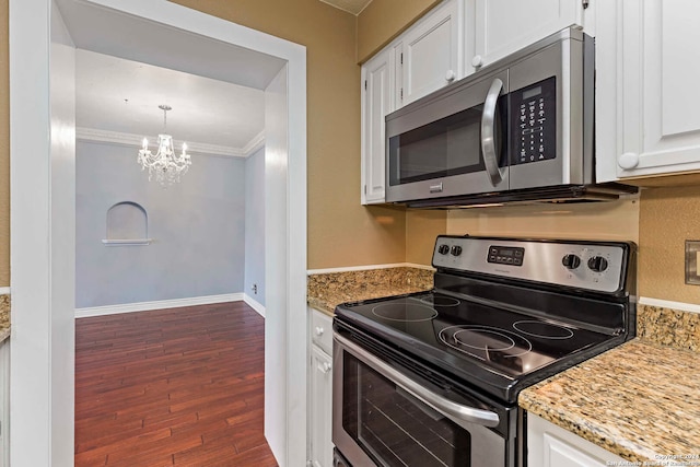 kitchen with dark wood-type flooring, stainless steel appliances, crown molding, an inviting chandelier, and white cabinets