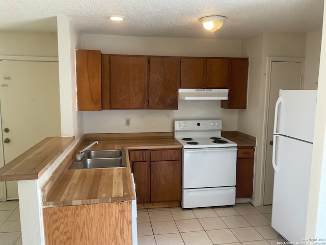 kitchen with sink, kitchen peninsula, a textured ceiling, and white appliances