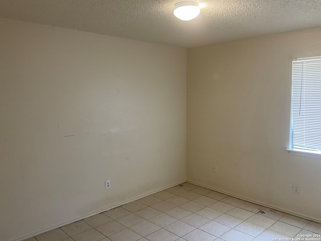 empty room with a textured ceiling and a wealth of natural light