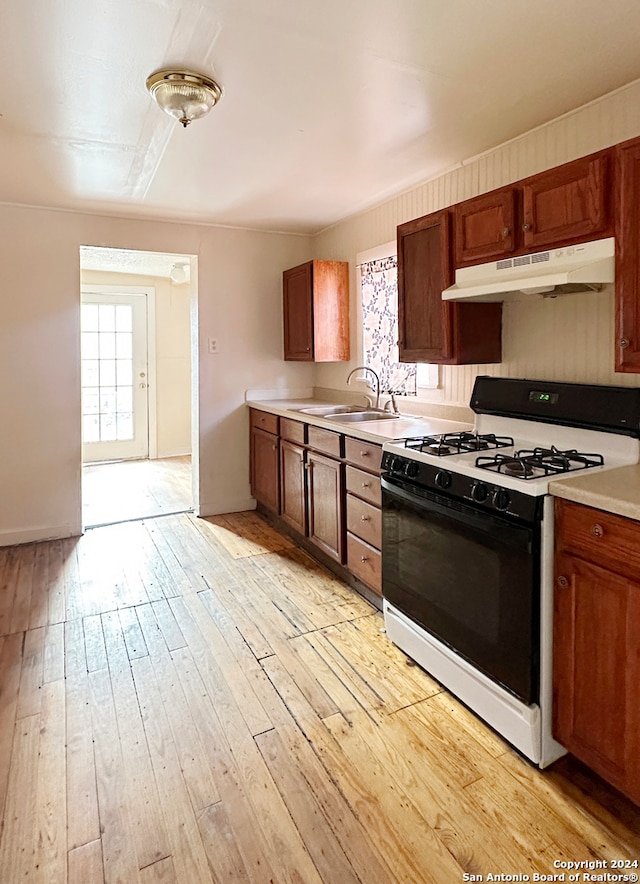 kitchen featuring light hardwood / wood-style flooring, gas range gas stove, and sink