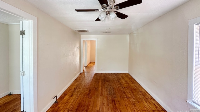 corridor featuring a textured ceiling and hardwood / wood-style floors