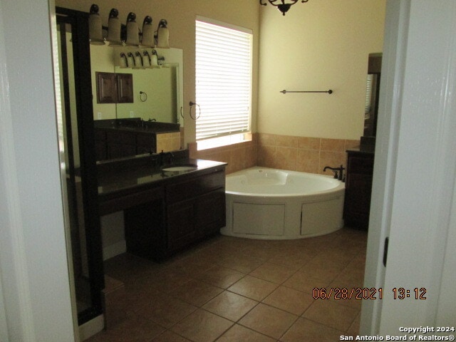 bathroom featuring a bathing tub, sink, and tile patterned flooring