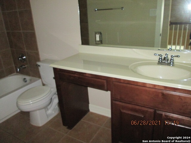 full bathroom featuring vanity, toilet, tile patterned flooring, and tiled shower / bath