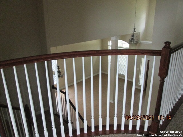 stairway featuring carpet flooring and an inviting chandelier