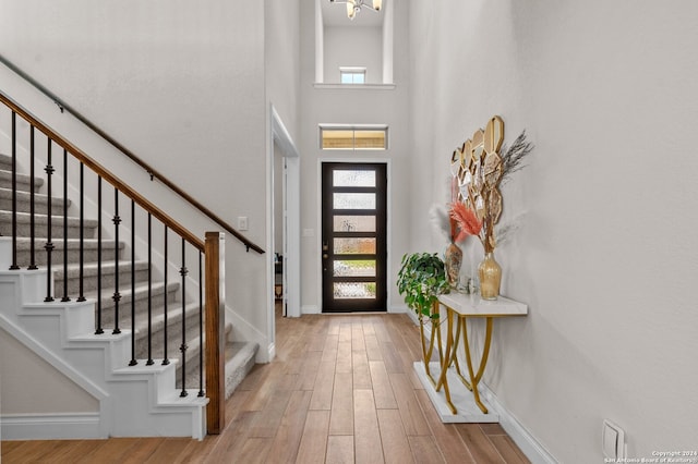 foyer with a towering ceiling and light hardwood / wood-style floors