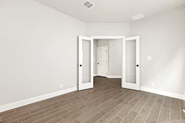 empty room with dark wood-type flooring and french doors