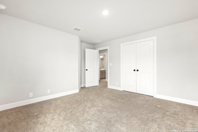 unfurnished bedroom featuring a closet and carpet floors