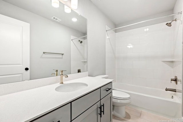 full bathroom featuring tile patterned flooring, vanity, tiled shower / bath combo, and toilet