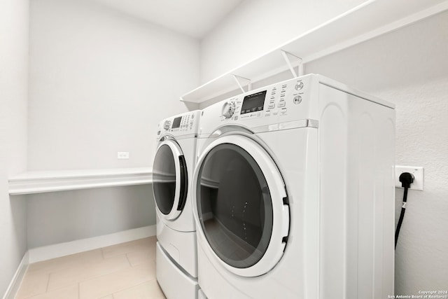 washroom with light tile patterned floors and washing machine and clothes dryer