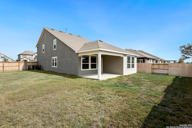 rear view of property with a lawn and a patio