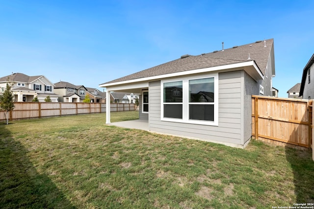 back of house featuring a patio area and a yard