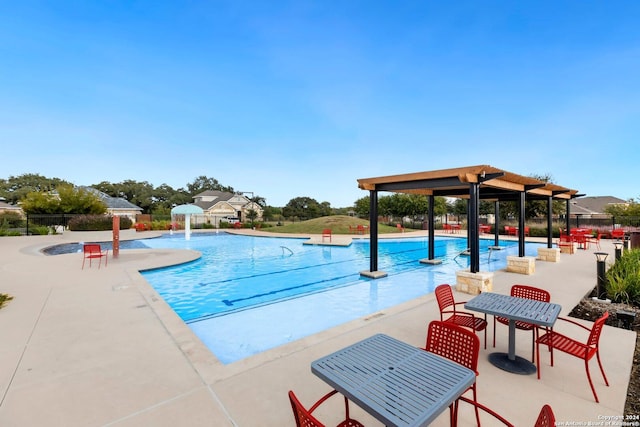 view of swimming pool with pool water feature and a patio area