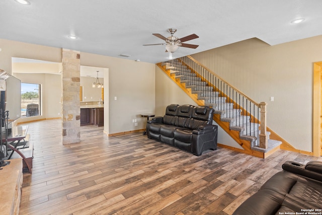 living room featuring hardwood / wood-style floors and ceiling fan with notable chandelier