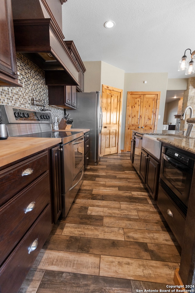 kitchen with tasteful backsplash, appliances with stainless steel finishes, sink, dark hardwood / wood-style flooring, and dark brown cabinetry