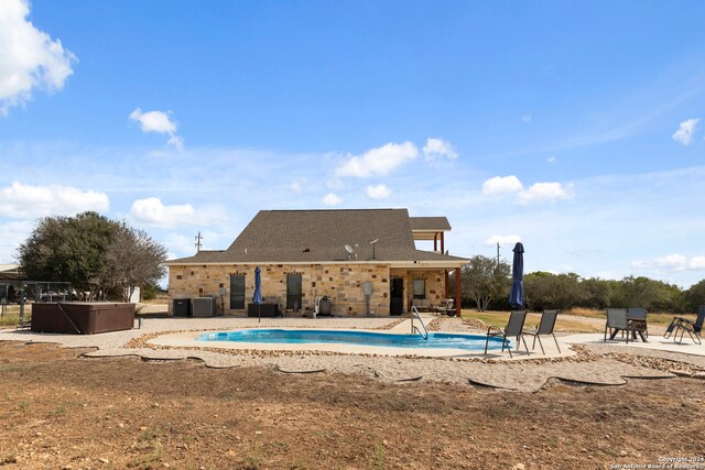 view of pool with a hot tub and a patio