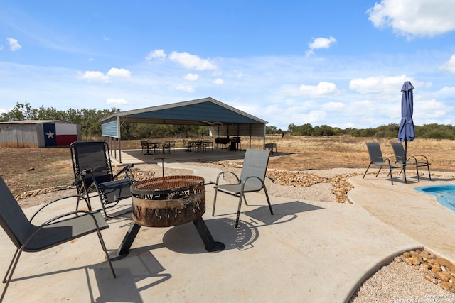 view of patio with a gazebo, a storage shed, and an outdoor fire pit