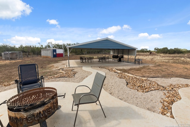 view of patio / terrace with a gazebo, a storage shed, and an outdoor fire pit