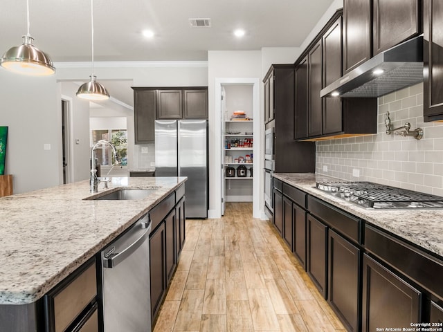 kitchen featuring light stone countertops, crown molding, appliances with stainless steel finishes, and sink