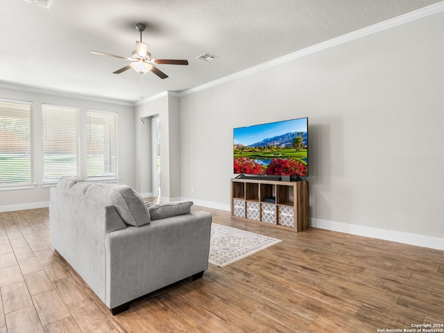 living room with light hardwood / wood-style floors, ornamental molding, a textured ceiling, and ceiling fan