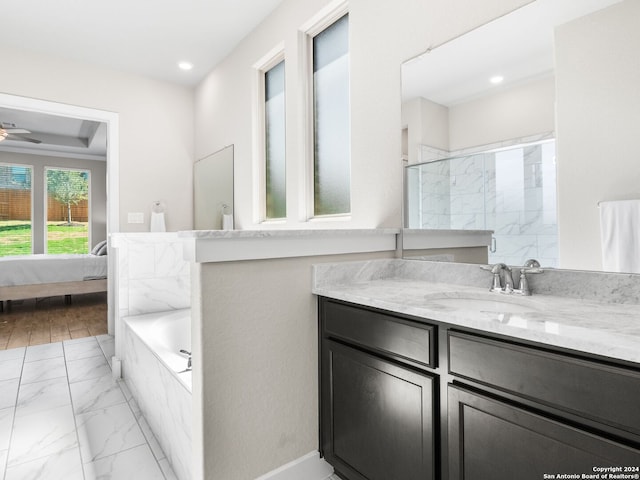 bathroom featuring vanity, a relaxing tiled tub, wood-type flooring, and ceiling fan