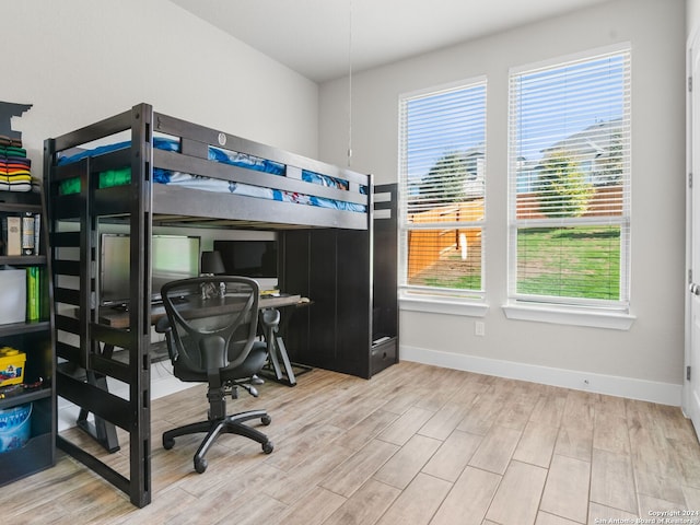 bedroom with multiple windows and light wood-type flooring