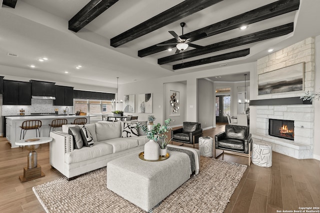 living room featuring light hardwood / wood-style floors, a healthy amount of sunlight, and beamed ceiling