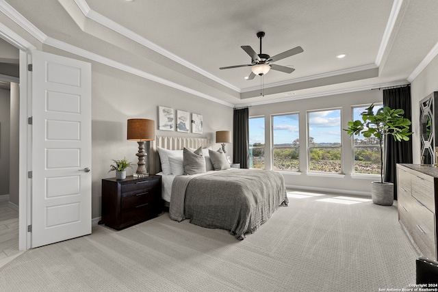 bedroom with ornamental molding, ceiling fan, light colored carpet, and a raised ceiling